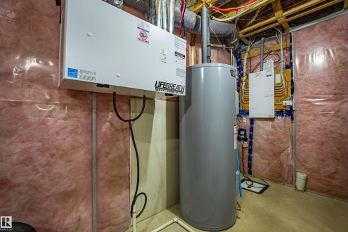 Utility room with water heater and electric panel - 2407 Casey Link, Edmonton, AB - Indoor Photo Showing Basement