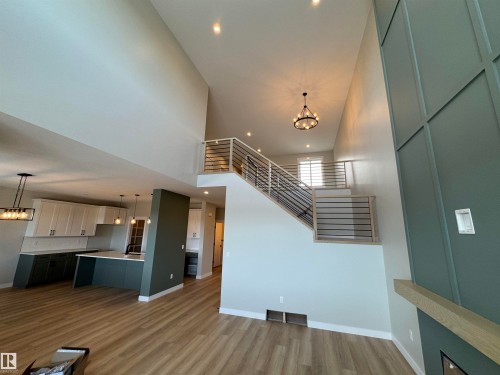 Unfurnished living room featuring hanging lights, a high ceiling, and dark wood-type flooring - 28 Harley Way, Spruce Grove, AB - Indoor Photo Showing Other Room