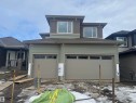 View of front of home featuring a garage, a shingled roof, and board and batten siding - 28 Harley Way, Spruce Grove, AB  - Outdoor With Facade 
