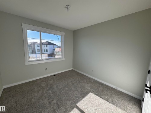 Carpeted empty room with baseboards - 28 Harley Way, Spruce Grove, AB - Indoor Photo Showing Other Room