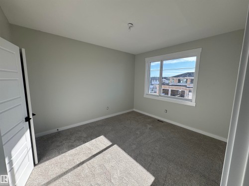 Carpeted spare room with baseboards - 28 Harley Way, Spruce Grove, AB - Indoor Photo Showing Other Room