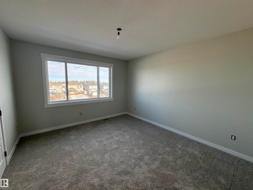 Spare room with carpet and a textured ceiling - 28 Harley Way, Spruce Grove, AB - Indoor Photo Showing Other Room