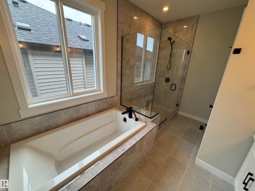 Bathroom featuring a bath, light tile patterned flooring, a stall shower, and recessed lighting - 28 Harley Way, Spruce Grove, AB - Indoor Photo Showing Bathroom