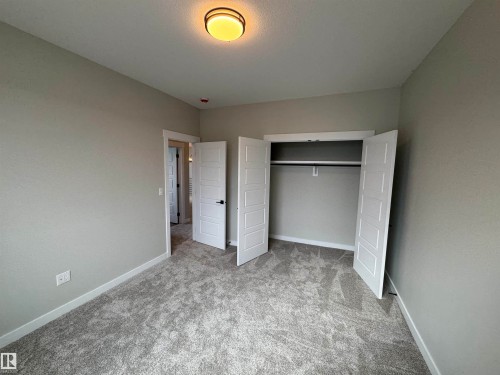 Unfurnished bedroom featuring a closet and light carpet - 28 Harley Way, Spruce Grove, AB - Indoor Photo Showing Other Room