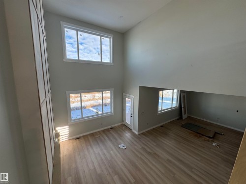 Unfurnished living room featuring light wood finished floors and lofted ceiling - 28 Harley Way, Spruce Grove, AB - Indoor Photo Showing Other Room