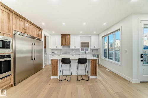 Kitchen featuring stainless steel appliances, brown cabinetry, recessed lighting, and light wood-style floors - 42 Elwyck Gate, Spruce Grove, AB - Indoor Photo Showing Kitchen With Stainless Steel Kitchen