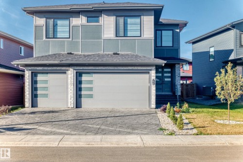 View of front facade featuring decorative driveway, roof with shingles, a garage, and a front yard - 42 Elwyck Gate, Spruce Grove, AB - Outdoor