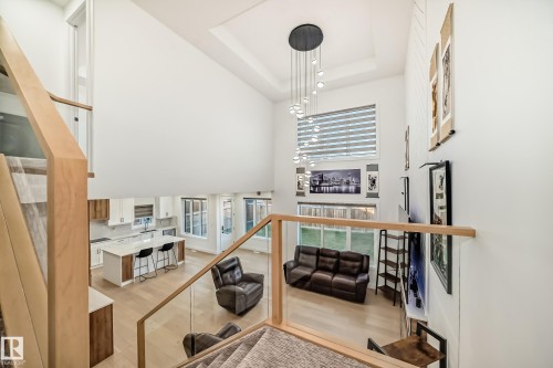 Living room featuring light wood-style floors, stairway, a tray ceiling, and a high ceiling - 42 Elwyck Gate, Spruce Grove, AB - Indoor Photo Showing Other Room
