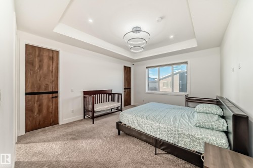 Carpeted bedroom featuring a raised ceiling and baseboards - 42 Elwyck Gate, Spruce Grove, AB - Indoor Photo Showing Bedroom