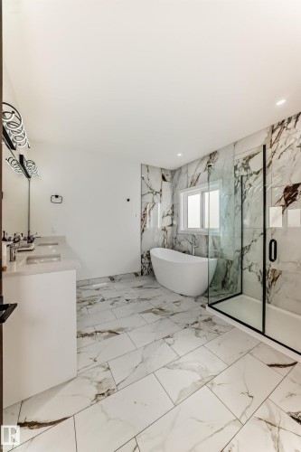 Bathroom featuring light marble finish floors, a freestanding tub, double vanity, a marble finish shower, and recessed lighting - 42 Elwyck Gate, Spruce Grove, AB - Indoor