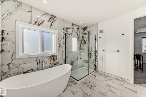 Bathroom featuring a freestanding tub, a marble finish shower, recessed lighting, marble tiled floors, and stone wall - 42 Elwyck Gate, Spruce Grove, AB - Indoor Photo Showing Bathroom