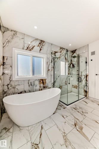 Bathroom with stone wall, marble tiled flooring, a soaking tub, a marble finish shower, and recessed lighting - 42 Elwyck Gate, Spruce Grove, AB - Indoor Photo Showing Bathroom