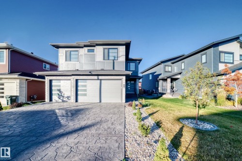 Contemporary home with decorative driveway, a front lawn, an attached garage, and board and batten siding - 42 Elwyck Gate, Spruce Grove, AB - Outdoor