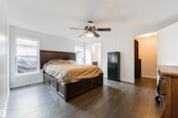 Bedroom featuring dark wood finished floors, ensuite bathroom, and ceiling fan - 