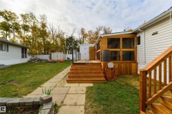 Fenced backyard with a sunroom, a deck, and a storage unit - 