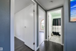Corridor featuring dark wood-style floors and a textured ceiling - 