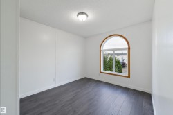 Unfurnished room with dark wood-style flooring and a textured ceiling - 