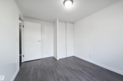 Unfurnished bedroom featuring dark wood-style flooring, a textured ceiling, and a closet - 