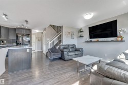 Living room featuring a textured ceiling, dark wood finished floors, and stairway - 