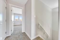 Corridor with light colored carpet and baseboards - 