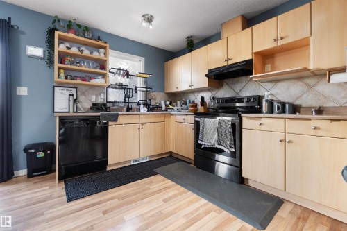 Kitchen with open shelves, electric stove, light brown cabinets, and dishwasher - 36 2503 24 Street, Edmonton, AB - Indoor Photo Showing Kitchen