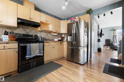 Kitchen featuring appliances with stainless steel finishes, light brown cabinets, and rail lighting - 36 2503 24 Street, Edmonton, AB - Indoor Photo Showing Kitchen