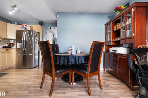 Dining room featuring a textured ceiling, light wood-style flooring, and a desk - 36 2503 24 Street, Edmonton, AB - Indoor