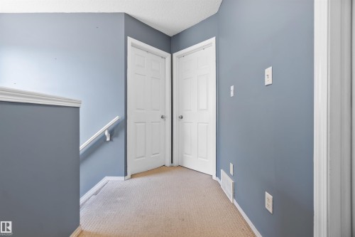 Hall with an upstairs landing, light carpet, and a textured ceiling - 36 2503 24 Street, Edmonton, AB - Indoor Photo Showing Other Room