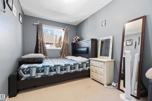 Bedroom with light colored carpet and a textured ceiling - 36 2503 24 Street, Edmonton, AB - Indoor Photo Showing Bedroom