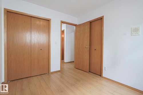 Main floor bedroom with light wood-style floors and a textured ceiling - 4631 43 Avenue, Edmonton, AB - Indoor Photo Showing Other Room