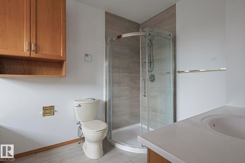 Bathroom featuring vanity, a shower stall, a textured ceiling, and light tile patterned floors - 4631 43 Avenue, Edmonton, AB - Indoor Photo Showing Bathroom