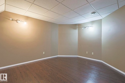 Rec room featuring a paneled ceiling and dark wood-style flooring - 4631 43 Avenue, Edmonton, AB - Indoor Photo Showing Other Room