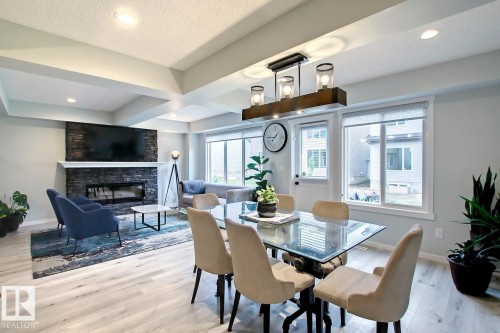 Dining space featuring light wood-style flooring, a fireplace, recessed lighting, and beamed ceiling - 19633 26A Av, Edmonton, AB - Indoor Photo Showing Dining Room With Fireplace