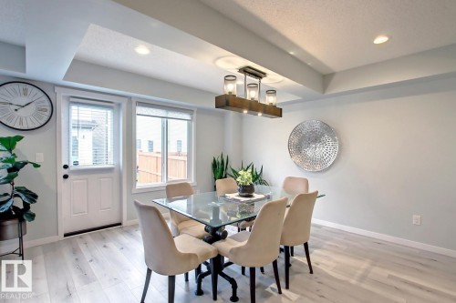 Dining room with recessed lighting, light wood finished floors, and a tray ceiling - 19633 26A Av, Edmonton, AB - Indoor Photo Showing Dining Room