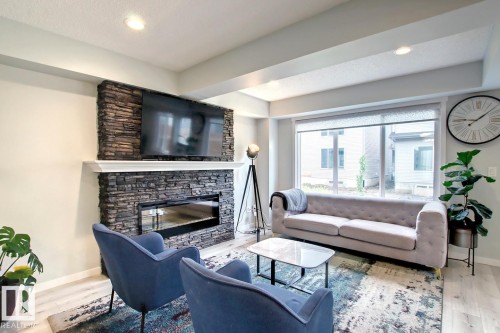 Living room featuring wood finished floors, a fireplace, and recessed lighting - 19633 26A Av, Edmonton, AB - Indoor Photo Showing Living Room With Fireplace