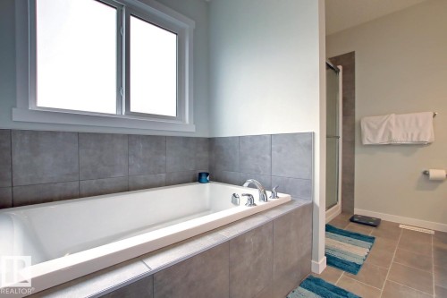 Bathroom featuring a garden tub, tile patterned flooring, and a shower stall - 19633 26A Av, Edmonton, AB - Indoor Photo Showing Bathroom