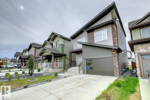 View of front of home featuring board and batten siding, stone siding, concrete driveway, and a garage - 19633 26A Av, Edmonton, AB - Outdoor With Facade