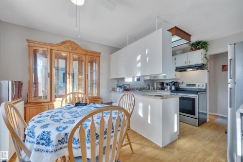 Kitchen featuring stainless steel appliances, light wood finished floors, light countertops, white cabinetry, and a peninsula - 5312 36 Ave, Wetaskiwin, AB - Indoor