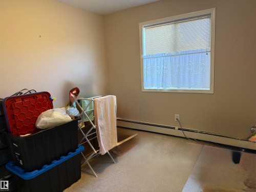 Living area with a baseboard radiator and light carpet - 415 4700 43 Avenue, Stony Plain, AB - Indoor