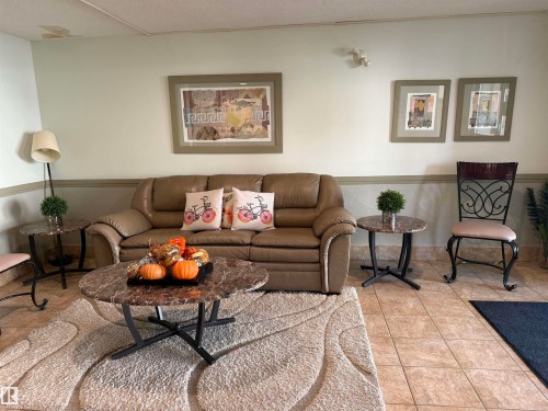 Living room with wainscoting and light tile patterned floors - 415 4700 43 Avenue, Stony Plain, AB - Indoor Photo Showing Living Room