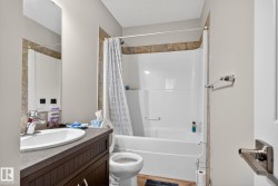 Full bath with shower / tub combo with curtain, vanity, and light wood-style floors - 