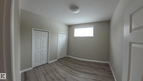 Unfurnished bedroom featuring multiple closets, a textured ceiling, and light wood finished floors - 196, 142 Selkirk Place, Leduc, AB - Indoor Photo Showing Other Room