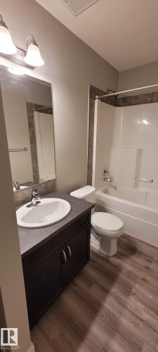 Bathroom with shower / tub combination, vanity, dark wood-type flooring, and a textured ceiling - 196, 142 Selkirk Place, Leduc, AB - Indoor Photo Showing Bathroom