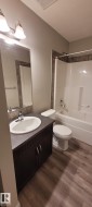 Bathroom with shower / tub combination, vanity, dark wood-type flooring, and a textured ceiling - 