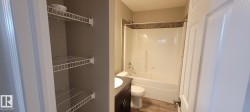 Full bath with vanity, washtub / shower combination, wood finished floors, and a closet - 