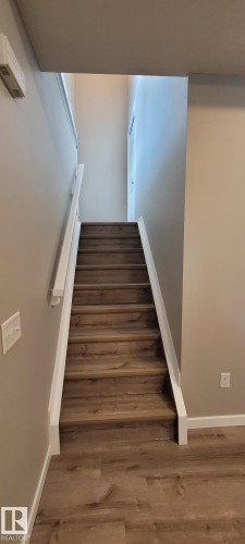 Staircase with wood finished floors and baseboards - 196, 142 Selkirk Place, Leduc, AB - Indoor Photo Showing Other Room