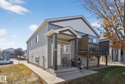 View of front of property featuring a front lawn and a wooden deck - 