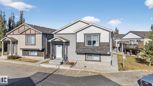 View of front facade with uncovered parking and stone siding - 196, 142 Selkirk Place, Leduc, AB - Outdoor With Facade