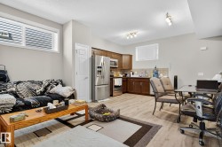 Living room featuring a desk, a textured ceiling, and light wood-style flooring - 