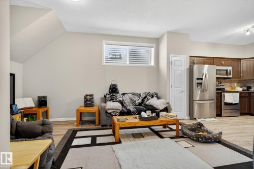 Living room featuring light wood-style flooring, a textured ceiling, and vaulted ceiling - 196, 142 Selkirk Place, Leduc, AB - Indoor